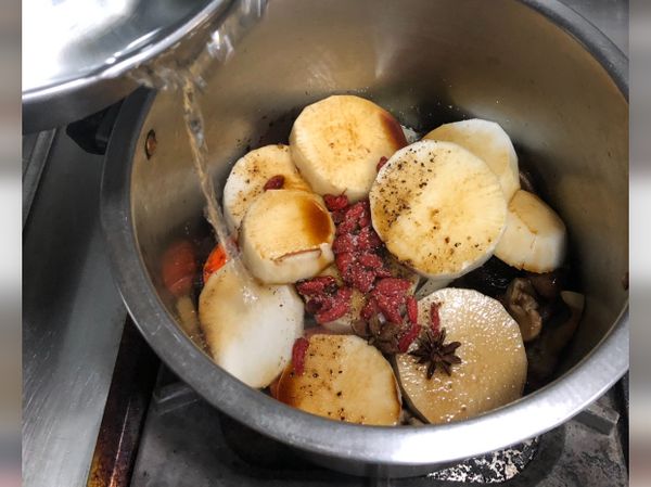 加入醬油、鹽巴及胡椒粉調味後，倒入水直至淹過食材，以小火慢燉，沸騰後可以試吃醬汁調鹹淡。