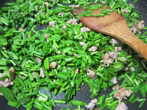 一小匙油爆香肉末後加入韭菜末快速拌炒，並以鹽調味，最後加一點點醬油和鍋邊淋上米酒提香後盛出。