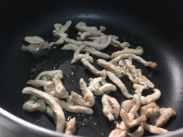 鍋中放入1湯匙油，肉絲下鍋炒至變白。