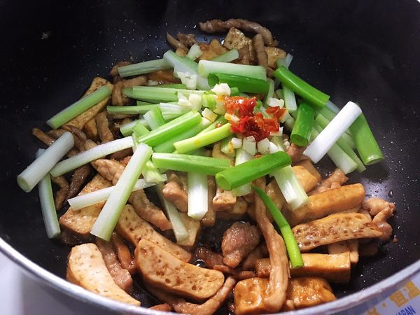 加入芹菜、蔥段、辣椒、蒜末、少許鹽巴，炒幾下。