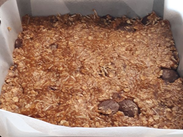 加入巧克力塊拌勻後倒進烘培盤子，壓緊緊