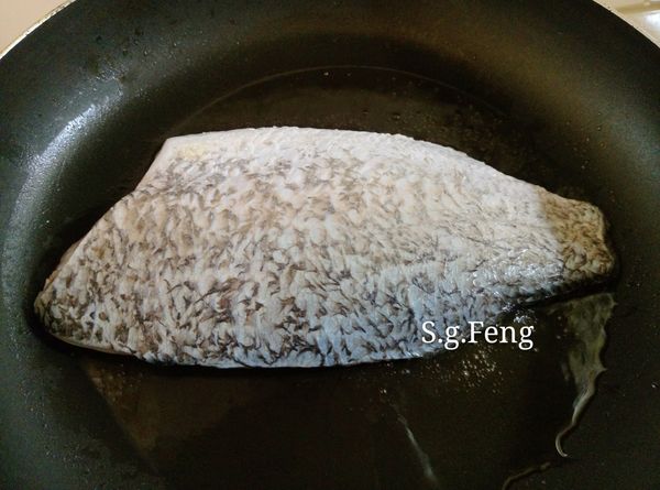 22.起鍋，開中小火，放入2大匙的油，油熱後放入鱸魚片，先不動魚片，煎約5-6分鐘。(鱸魚片下鍋前先用餐巾紙擦乾水份，避免水份油爆)