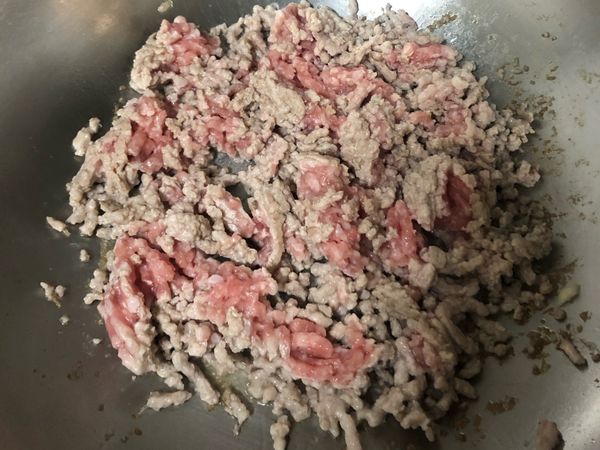 起油鍋，然後將豬絞肉下鍋炒至熟