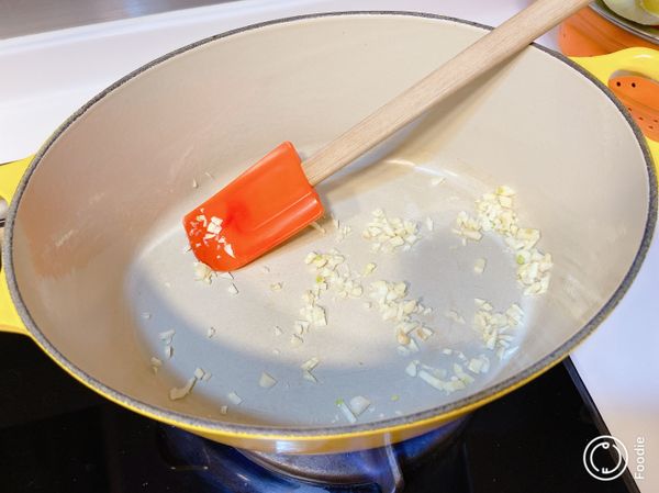 先將鍋燒熱，加入蒜蓉炒香。加入薯仔、紅蘿蔔及肉粒伴勻。