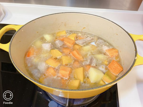 加入700毫升水，以中慢火煮10分鐘。加入南瓜，再煮10分鐘。