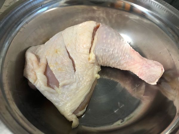 首先清洗雞腿，然後將表面的水擦乾，
在雞腿肉較厚的地方劃上三刀（如圖）.