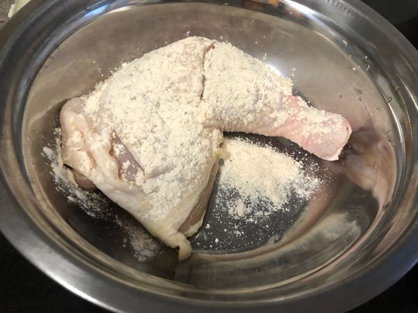 在雞腿正面灑上炸雞粉.