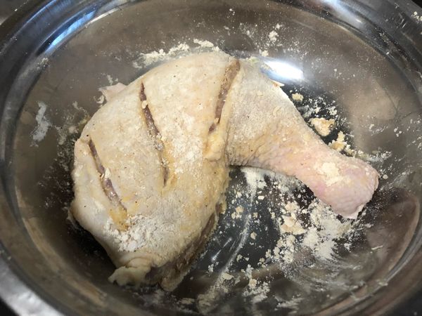 再翻回正面，用手將旁邊的粉抓放在未灑到粉的地方.雞腿上的粉不用厚厚一層，有沾到粉即可.