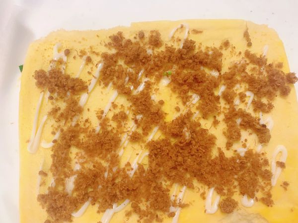 取出烤火的蛋糕捲待涼後翻面撕掉烤紙再適量抹上美乃滋跟肉鬆