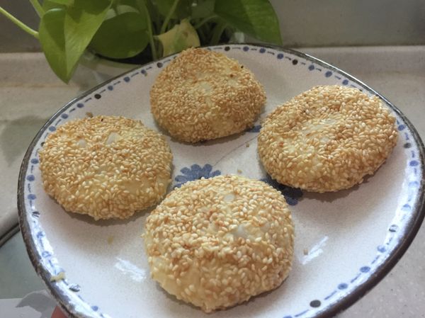 將馬鈴薯蒸熟後壓成泥狀，拌入一些鹽、糖，然後一個一個包入切小塊的起司片，揉成圓餅狀，再沾上白芝麻，下鍋油煎即完成！