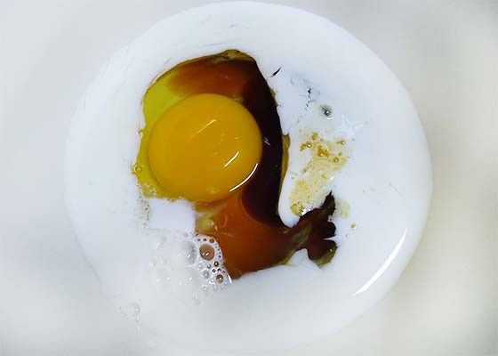 大碗中打入蛋，加入牛奶及桑菊飲拌勻
