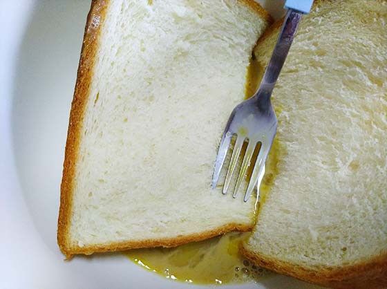 將吐司放入大碗中，將表面都裹上蛋奶液