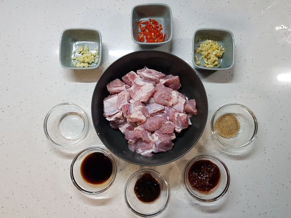 將糖、郫縣辣豆瓣醬、蠔油、醬油、米酒、薑、大蒜、辣椒等醃肉料，倒入豬小排。