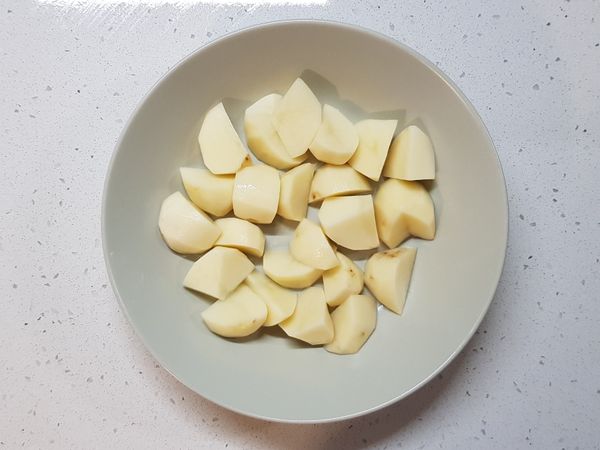 準備一個蒸盤，底部鋪上一層馬鈴薯。