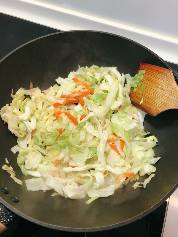 用原來的鍋子下高麗菜絲、紅蘿蔔絲，拌炒至稍微軟化。