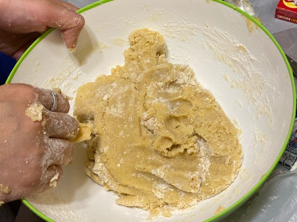 用大碗將牛油及糖用手搓勻，再拌入蛋、精油及鹽，拌好後再逐少搓入麵粉。