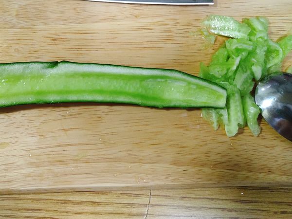 將小黃瓜對半切、並利用湯匙將籽刮除。