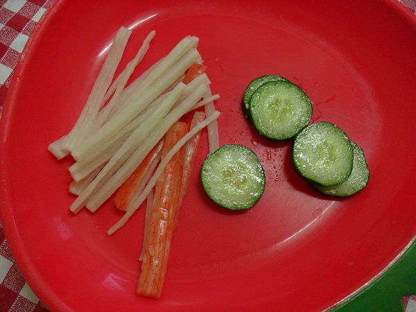 小黃瓜切片備用，蟹肉棒洗淨切半備用。