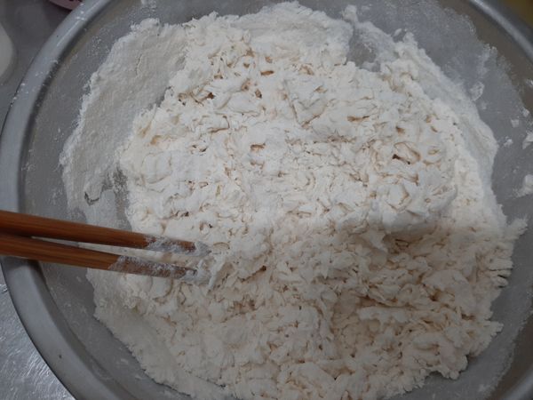 成絮狀後再加入冷水（半杯），開始和麵糰