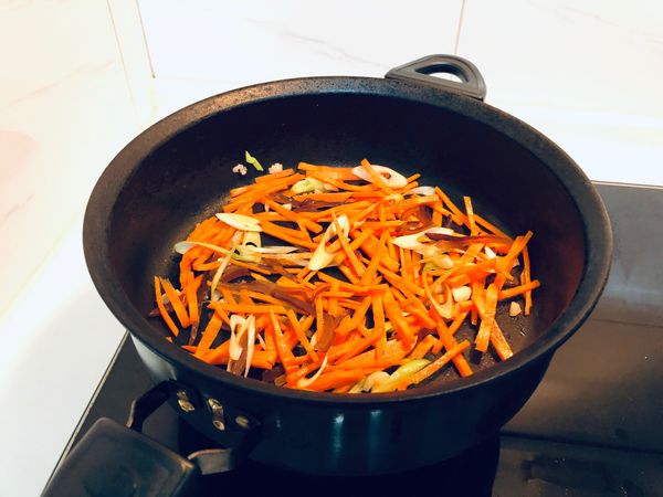 紅蘿蔔洗淨、去皮、切絲
木耳洗淨、切絲
蒜苗洗淨、切片
蒜頭洗淨、去皮、切末
豆干絲洗淨，切兩刀（這樣才不會太長打結在一起）


放入油鍋將蒜頭、蒜苗爆香；
接著放入紅蘿蔔絲、木耳絲拌炒；