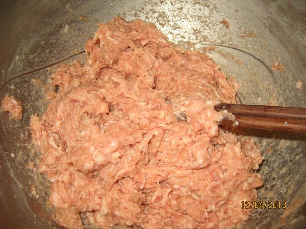 分次將水加入[作法一]打水。(打水是為讓肉餡能夠保有水分，吃的時候肉才會軟，也會有湯汁，只要把水加入肉餡中用筷子同方向攪拌至水完全吸收進去。)