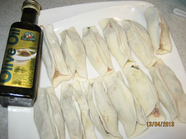 包餡取適量的餡放於麵皮中央，將麵皮對摺黏緊成長條型。