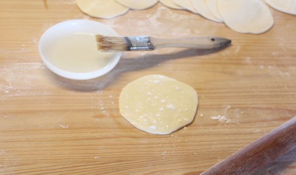 取一張麵皮，抹上一層油，再灑些麵粉。