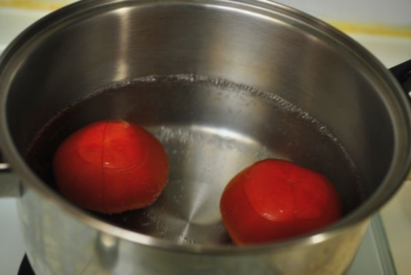 鍋中水開後,放入牛番茄,燙至番茄切十字部位的皮微微翹起.