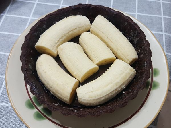 冰箱取出派皮，裡面生巧克力已稍微凝固，放入香蕉。