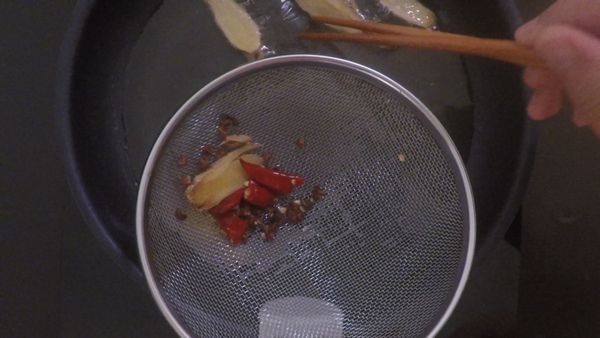 取鍋加入沙拉油，油熱後下老薑、辣椒及花椒。煸出香味後先將辣椒跟花椒取出切碎備用