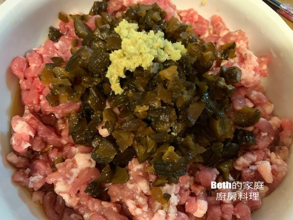 找一個深盤，放入豬絞肉，瓜子肉的醬汁；醬瓜切成小丁放在絞肉上，加上磨好的薑泥、白胡椒粉用筷子拌勻
