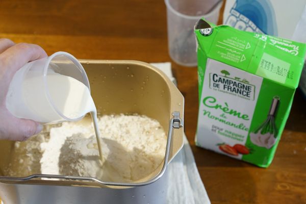 將麵粉、鹽、鮮奶油和加了酵母的溫水放入麵包機揉成麵糰。