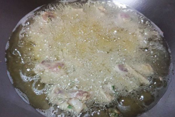熱鍋後倒入食用油，採用中溫來做油炸的動作，慢慢油炸保持雞肉的水份不流失，雞肉表面開始上色後撈起來備用
