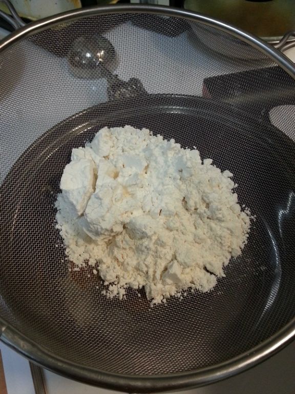 將蛋黃放入容器中加入牛奶和無鹽奶油打勻,再加入低筋麵粉和泡打粉(需過篩)