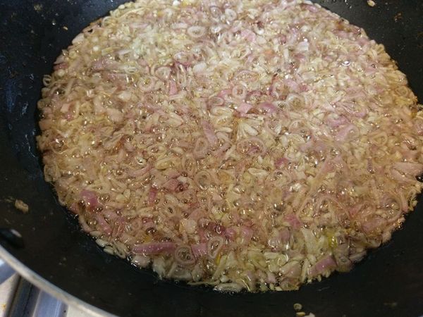 等到油脂都逼出來之後，將油渣撈出，然後將紅蔥頭和少許鹽巴倒進雞油中，將紅蔥頭炸到金黃