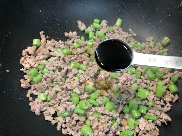 將肉炒熟，加入50g四季豆再加1小匙醬油炒熟