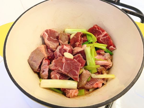 1.鑄鐵鍋內倒入10ml油及牛肉的多餘油花，開中小火
2.丟入蒜頭薑蔥段，炒出香味後丟入牛肉，拌炒至牛肉表面變色後將肉夾出