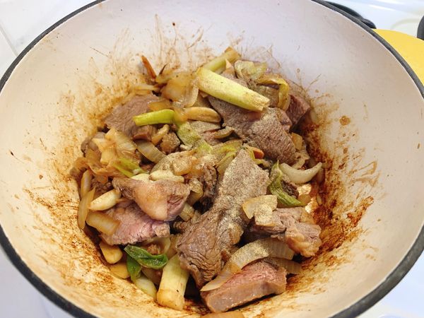 1.放入洋蔥丁拌炒，洋蔥變透明時，下3大匙米酒
2.夾出一開始丟入的油花，放入牛肉，再倒入花椒粒及白胡椒粉拌炒