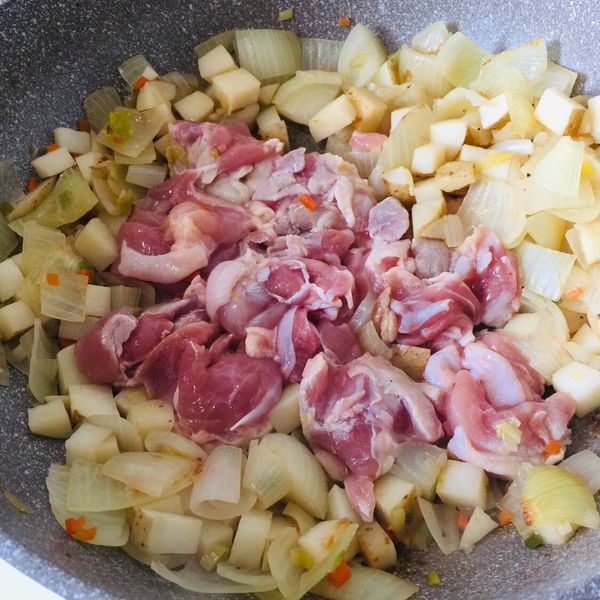 洋蔥/馬鈴薯悶軟後加人雞腿排，皮朝下。