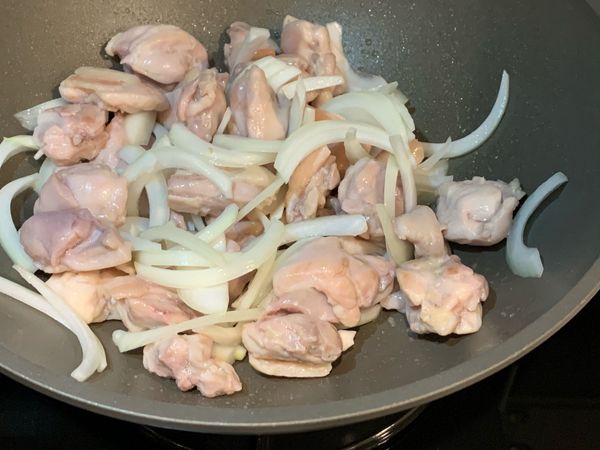 鍋中加入少許油加熱，雞腿肉皮面朝下入鍋，煎至兩面上色即可加入洋蔥一起翻炒至洋蔥變軟。