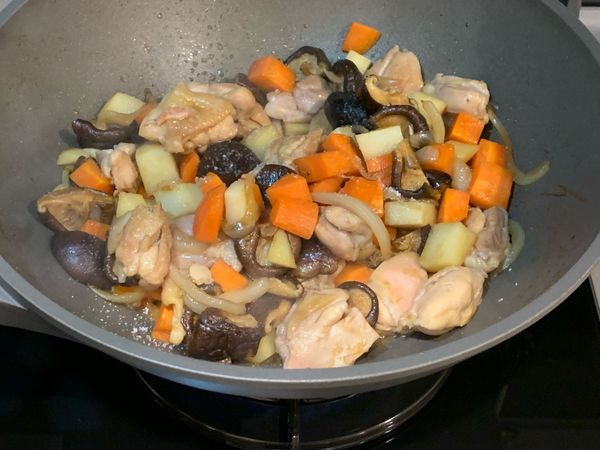 依序加入乾香菇、紅蘿蔔和馬鈴薯丁(瀝乾水分)，拌炒均勻逼出香氣，然後從鍋邊嗆入調味醬料的醬油及醬油露，再加入糖及鹽調味。