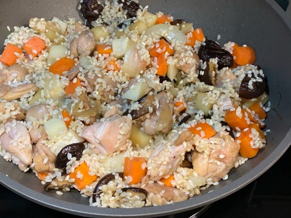 將白米加入，翻炒均勻讓米粒吃油。