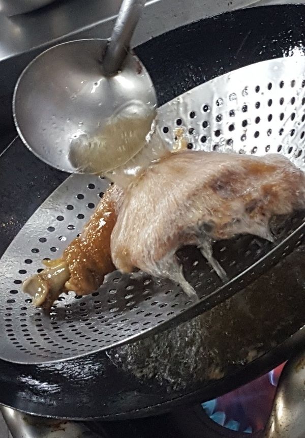 起油鍋, 等油熱, 用漏勺接著雞腿, 另一邊用鍋鏟將熱油撈起, 慢慢淋上雞皮上,反覆操作直到雞皮酥脆即變金黃色即可.