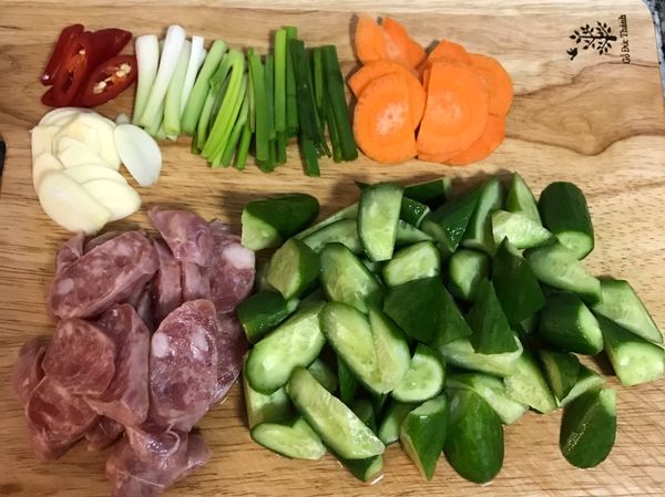 蒜頭去皮切片；香腸切片；小黃瓜去頭去尾後滾刀切；