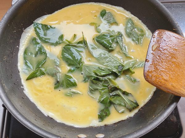 九層塔、蛋、鮮味炒手攪勻後，熱油鍋下，翻炒2分鐘