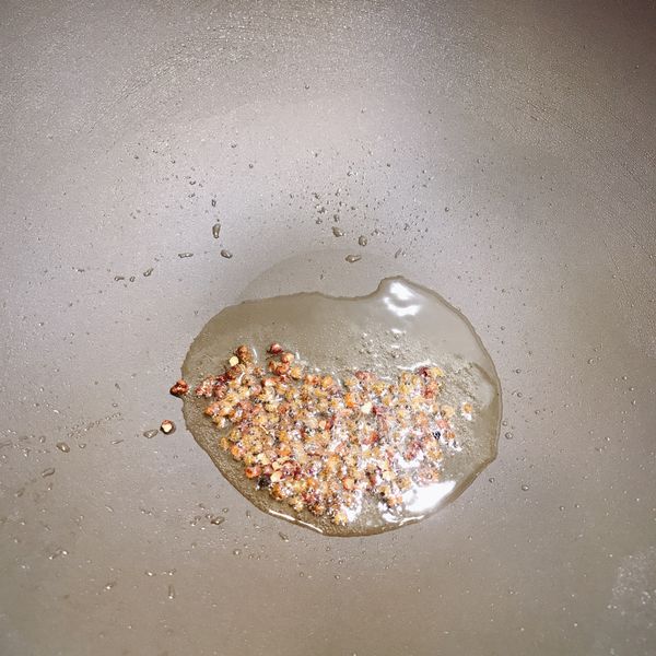 熱鍋加入油燒熱後，加入花椒粒爆香。