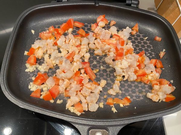 先將蒜末炒香，放入蝦仁及番茄塊拌炒，炒至蝦仁微紅後再放入木耳絲、菇菇，蓋上鍋蓋悶煮約2分鐘。