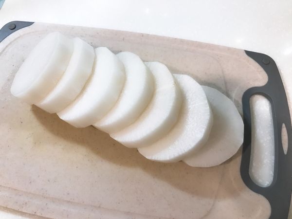 白蘿蔔外皮洗淨、擦乾、削皮，再切成厚1.5公分的圓片狀。