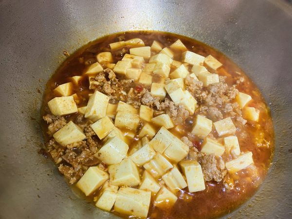 1. 蒜末爆香，下絞肉、辣豆瓣醬、醬油、糖、白胡椒粉、米酒，拌炒至肉上色。

2. 接下來放豆腐並加水大概蓋過豆腐一半就好，轉中小火煨煮入味。