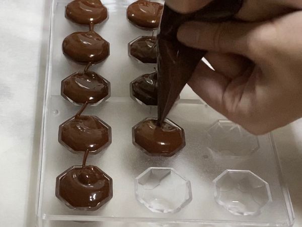 擠入模子中倒出多餘巧克力，刮平冷藏。